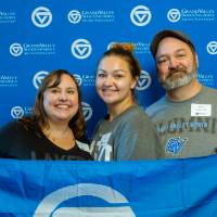 Three alumni pose for a photo